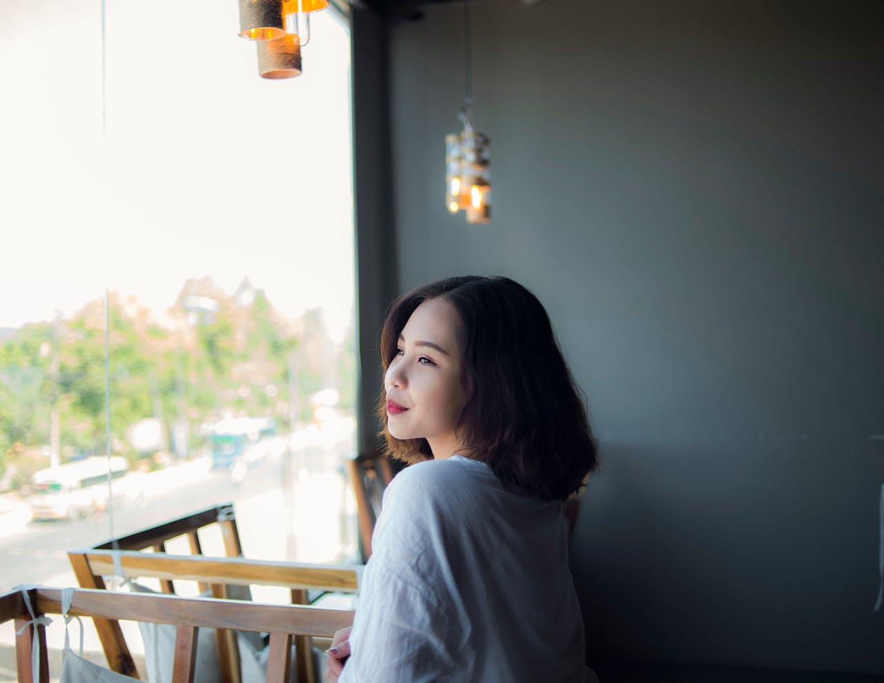 Elegant profile of a smiling woman gazing outside a window in Vietnam.